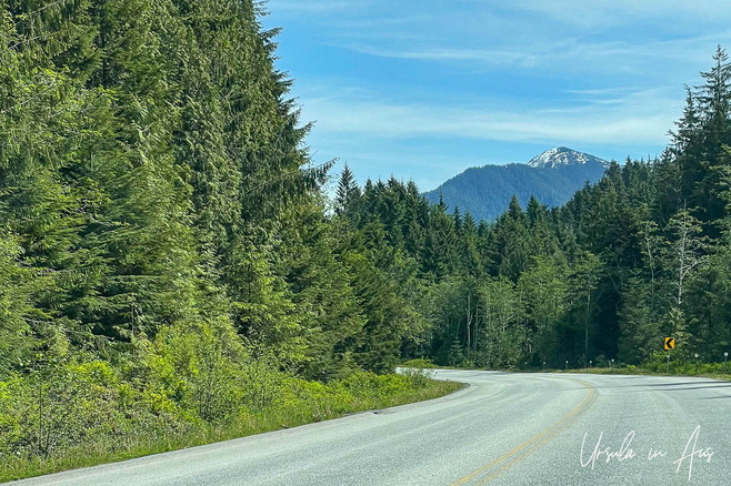 A curve in Highway 16 with trees and mountains, Prince Rupert, BC, Canada