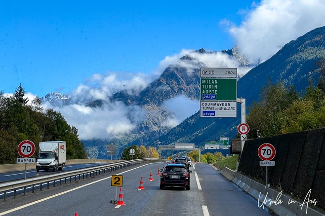 Highway signs and vehicles on the approach to the Mont Blanc Tunnel, France. 