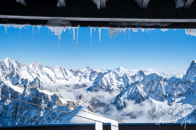 View over the Mont Blanc massif, framed by icicles on the roof of the cable car station viewing platform, Chamonix France